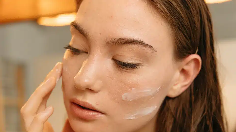 Application de cr&egrave;me sur la peau du visage